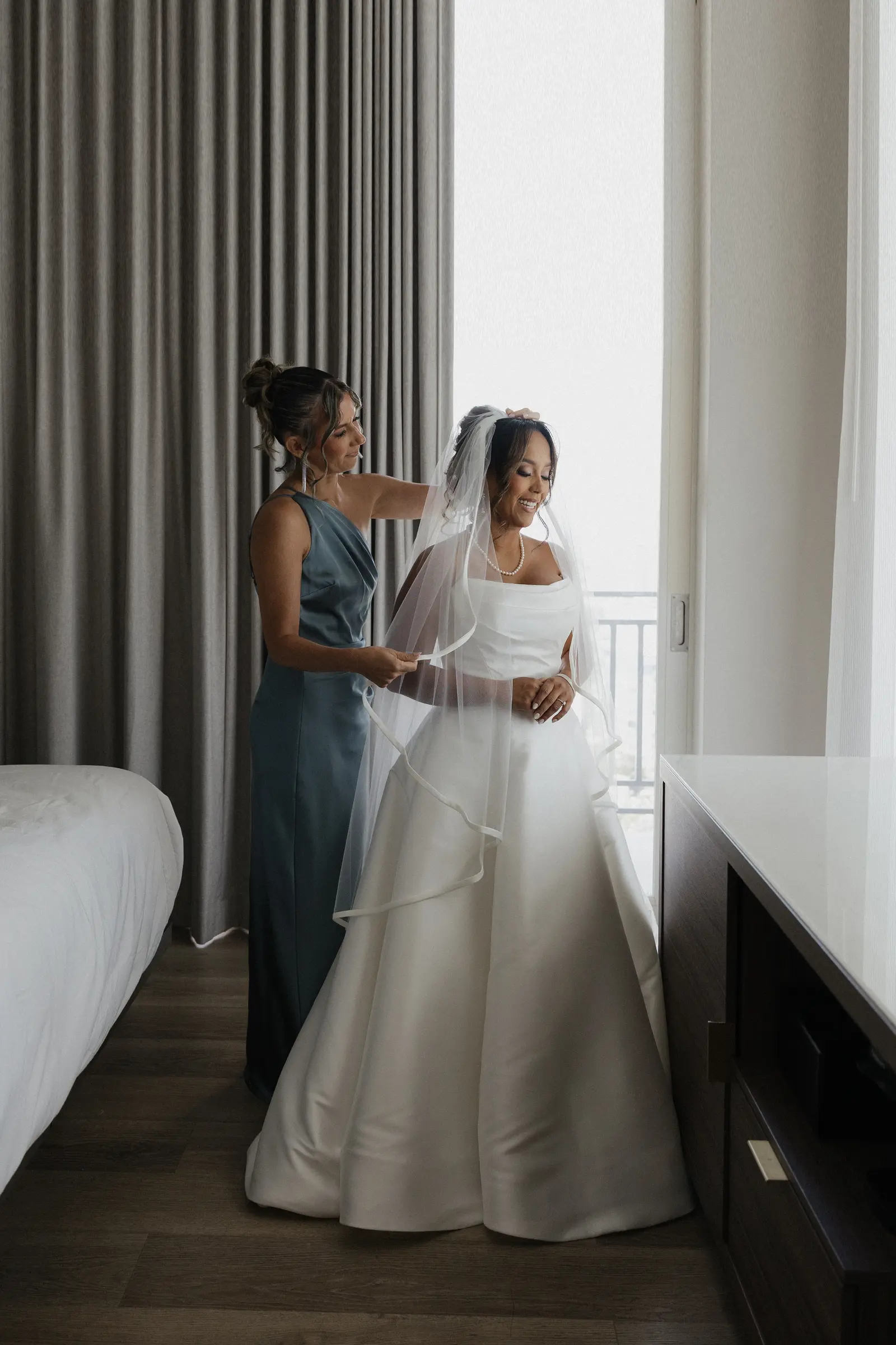 Bride and bridesmaids by a window before the ceremony