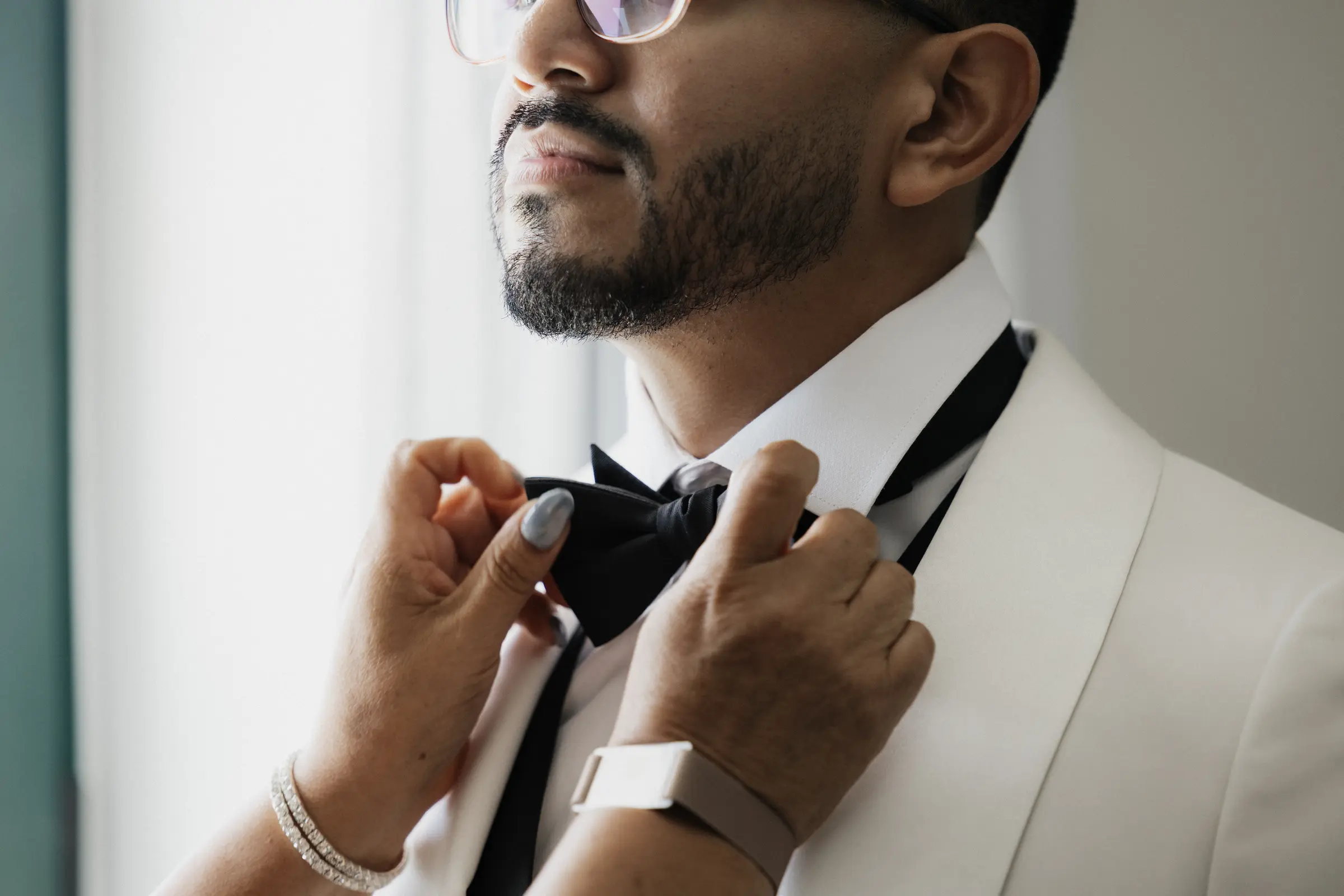 Groom adjusting his bow tie