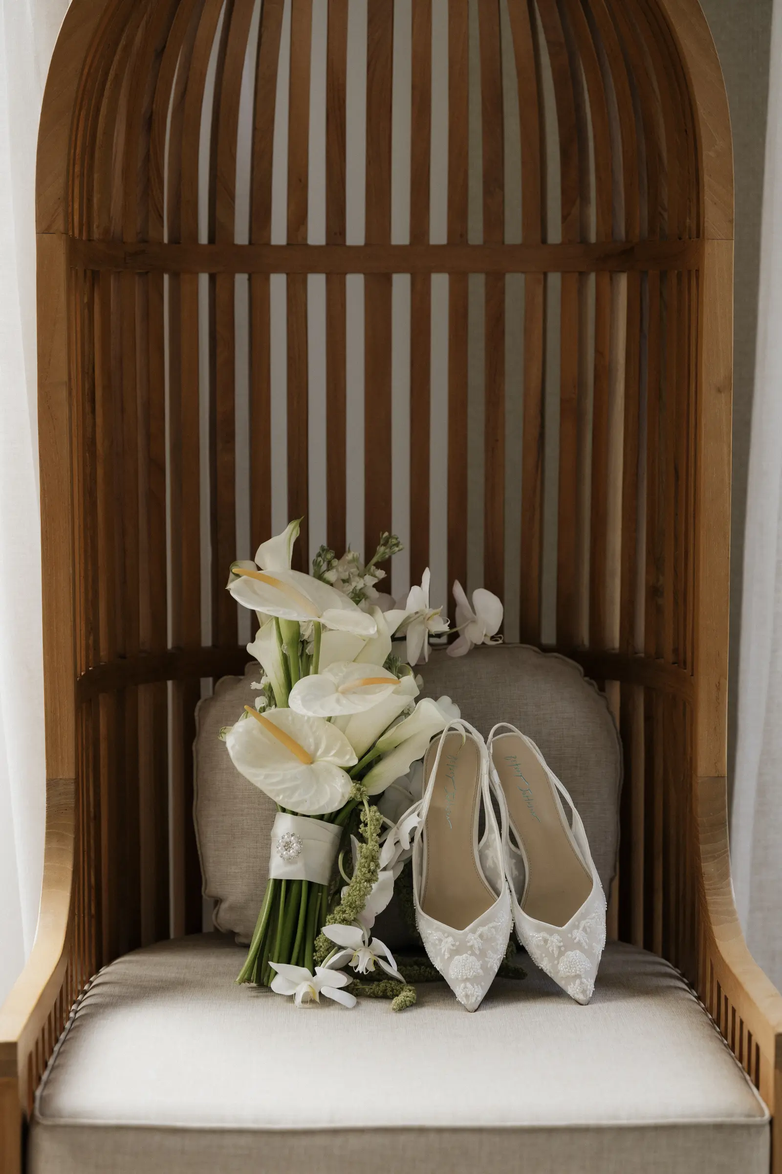 Bridal bouquet and shoes resting on a chair