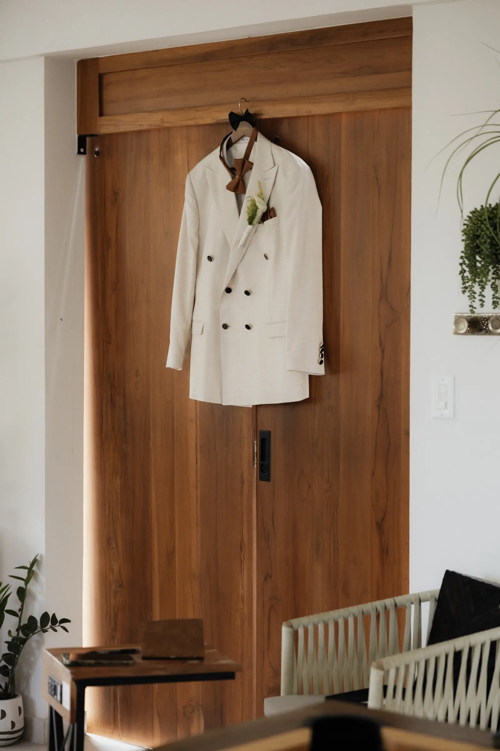 Groom's jacket hanging on a wooden door