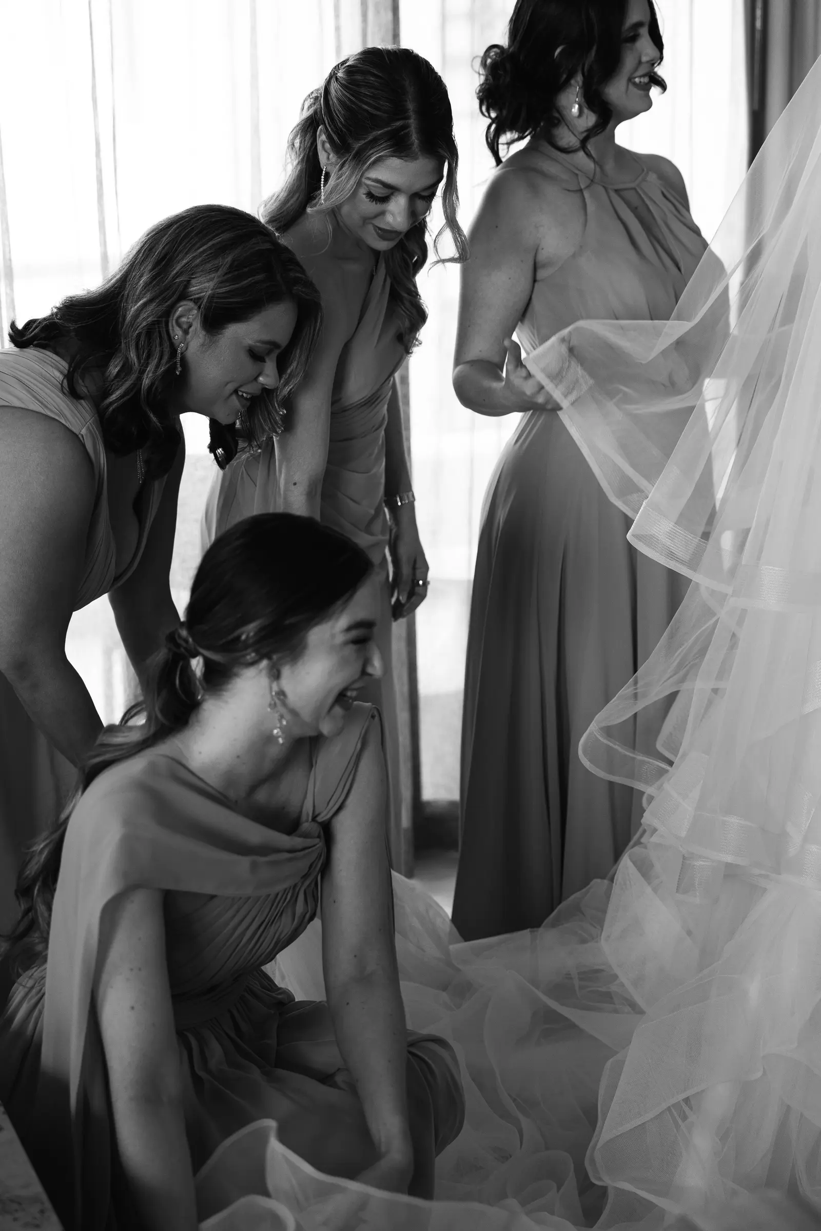 Bridesmaids helping the bride with her veil