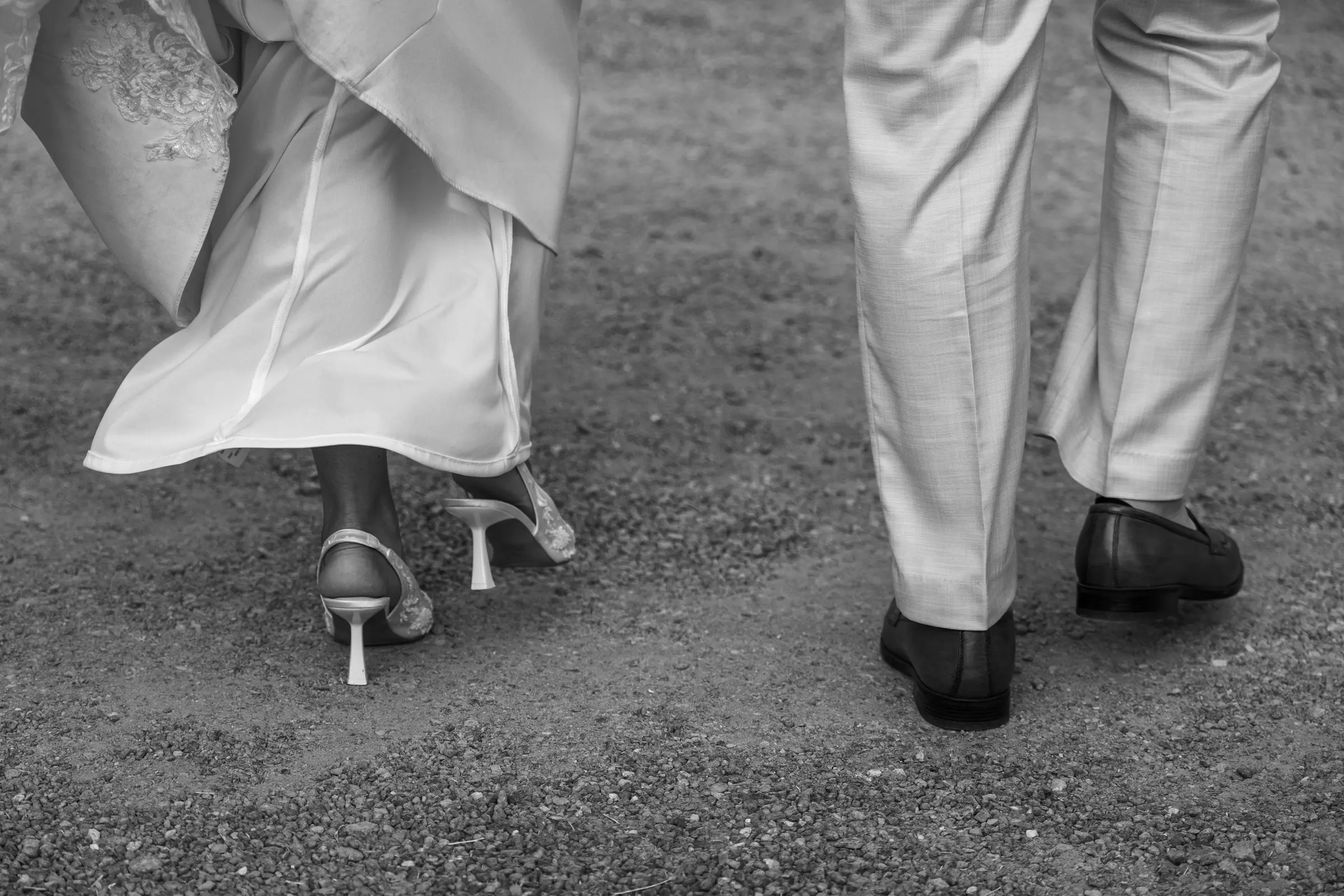 Close-up of the bride's shoes and dress hem outdoors