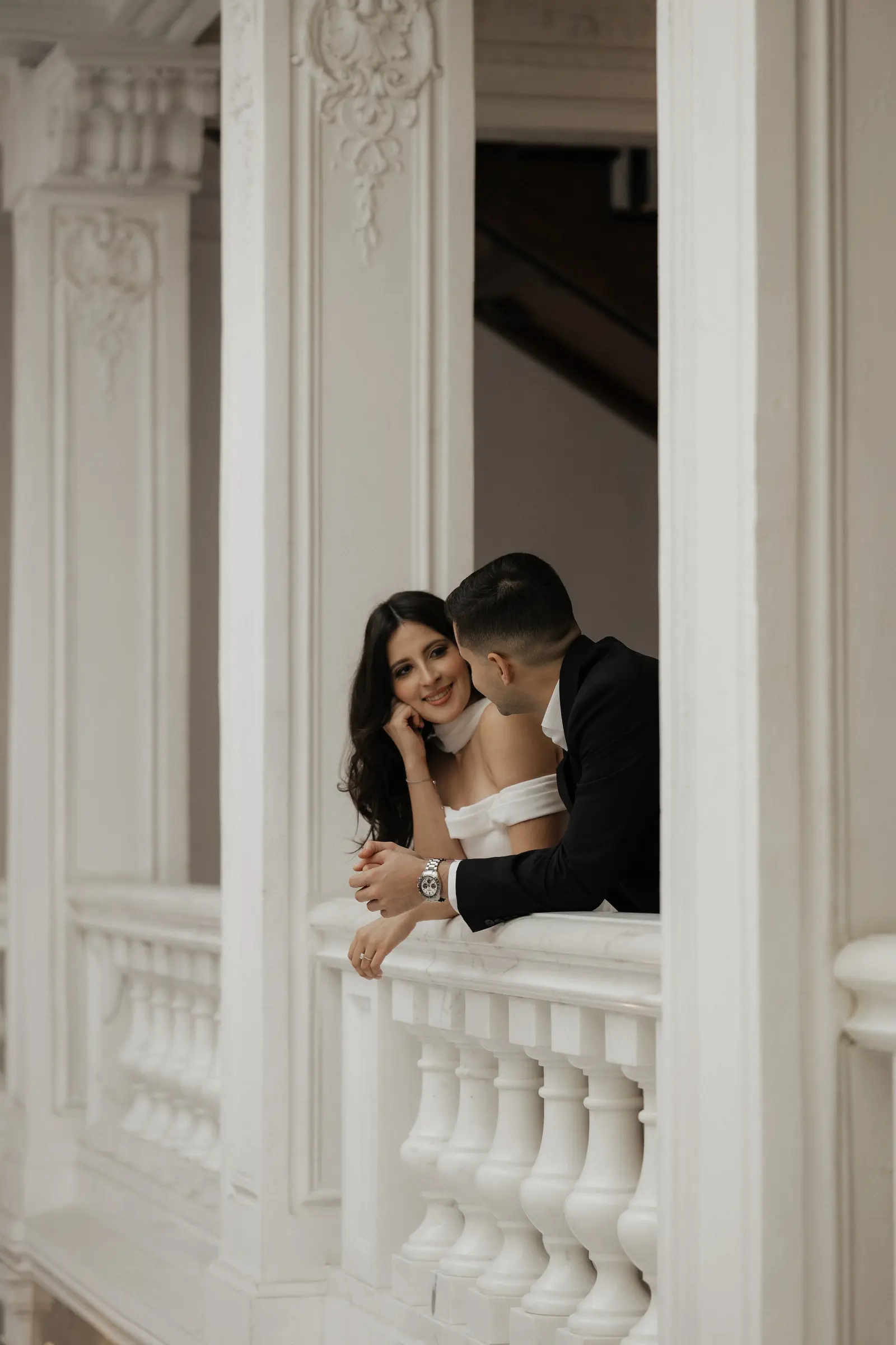 Bride and groom embracing on a balcony