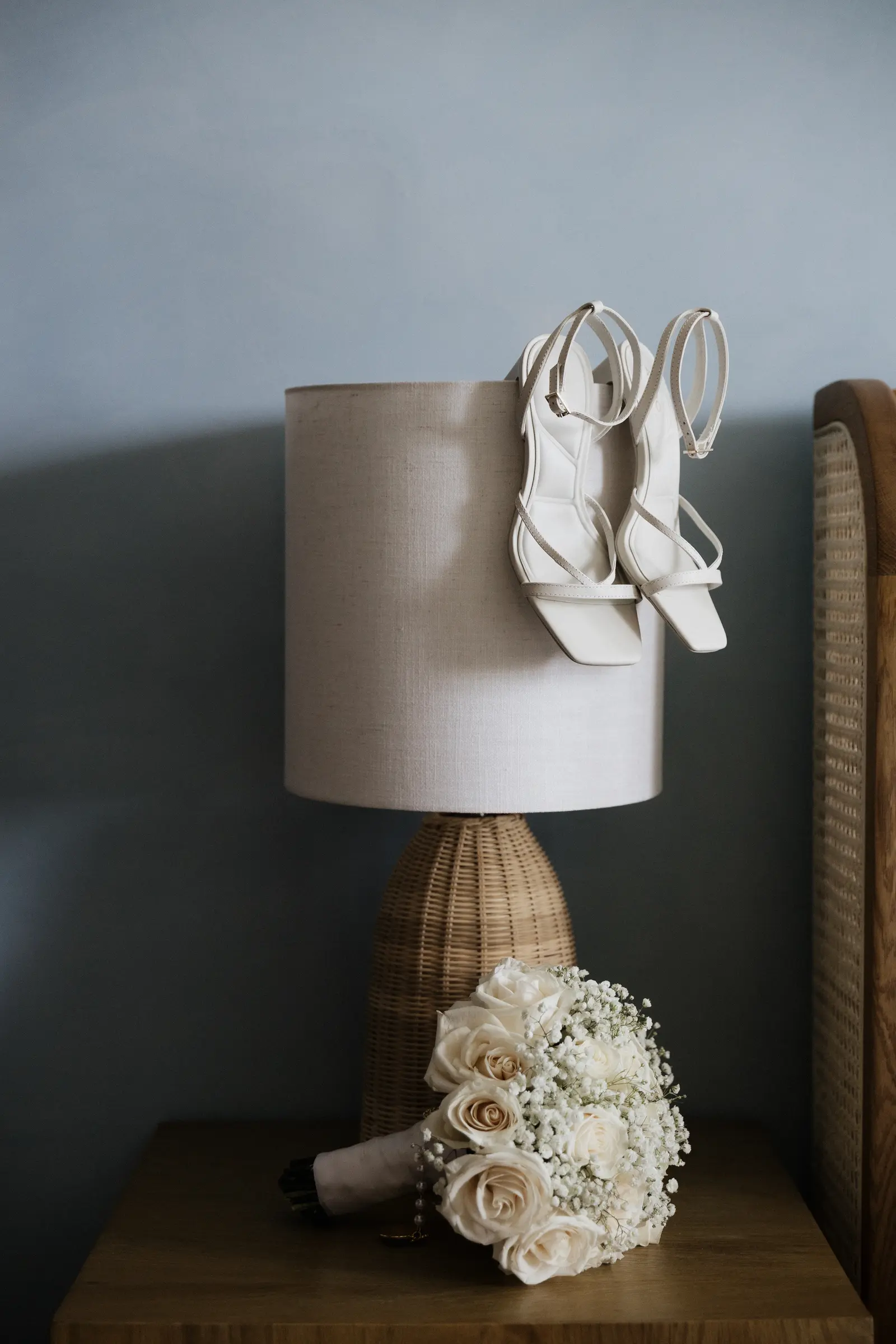 Bridal shoes and bouquet on a bedside table