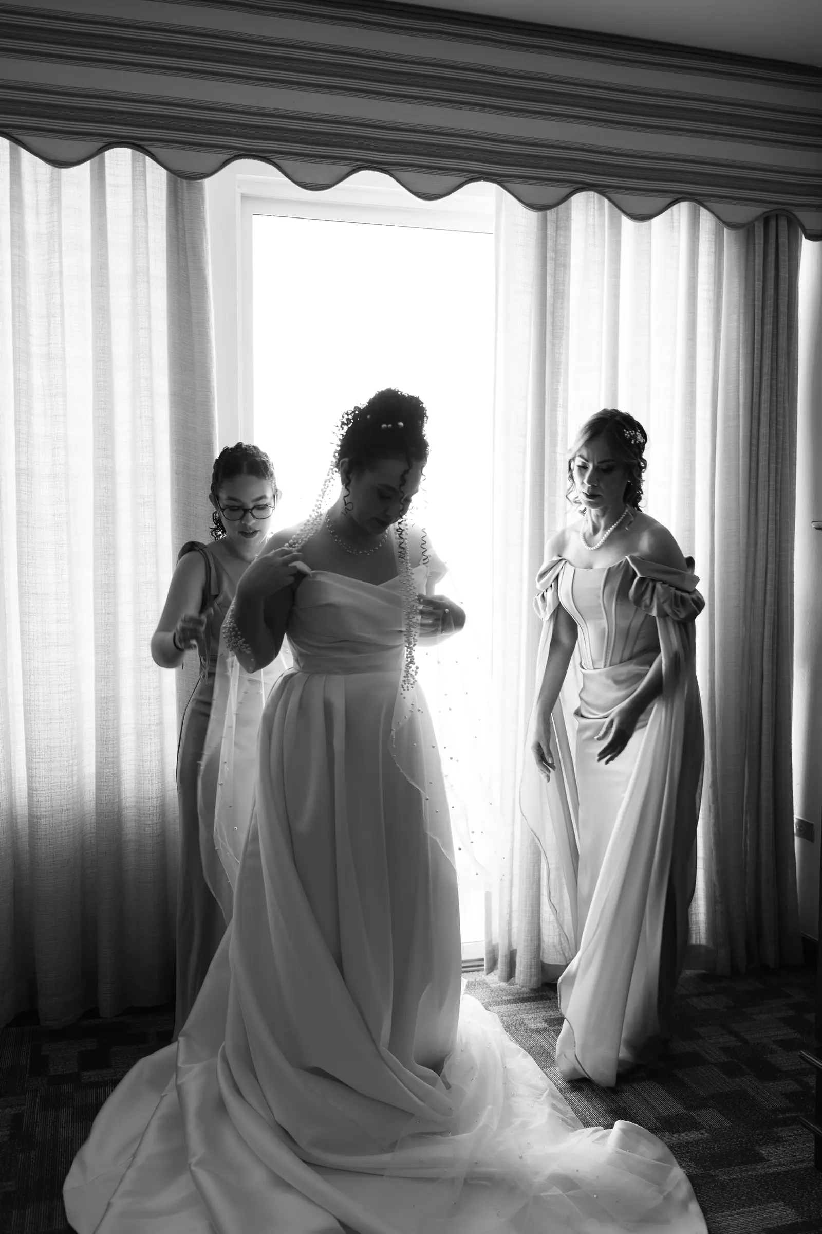 Bridesmaids getting ready together by a window