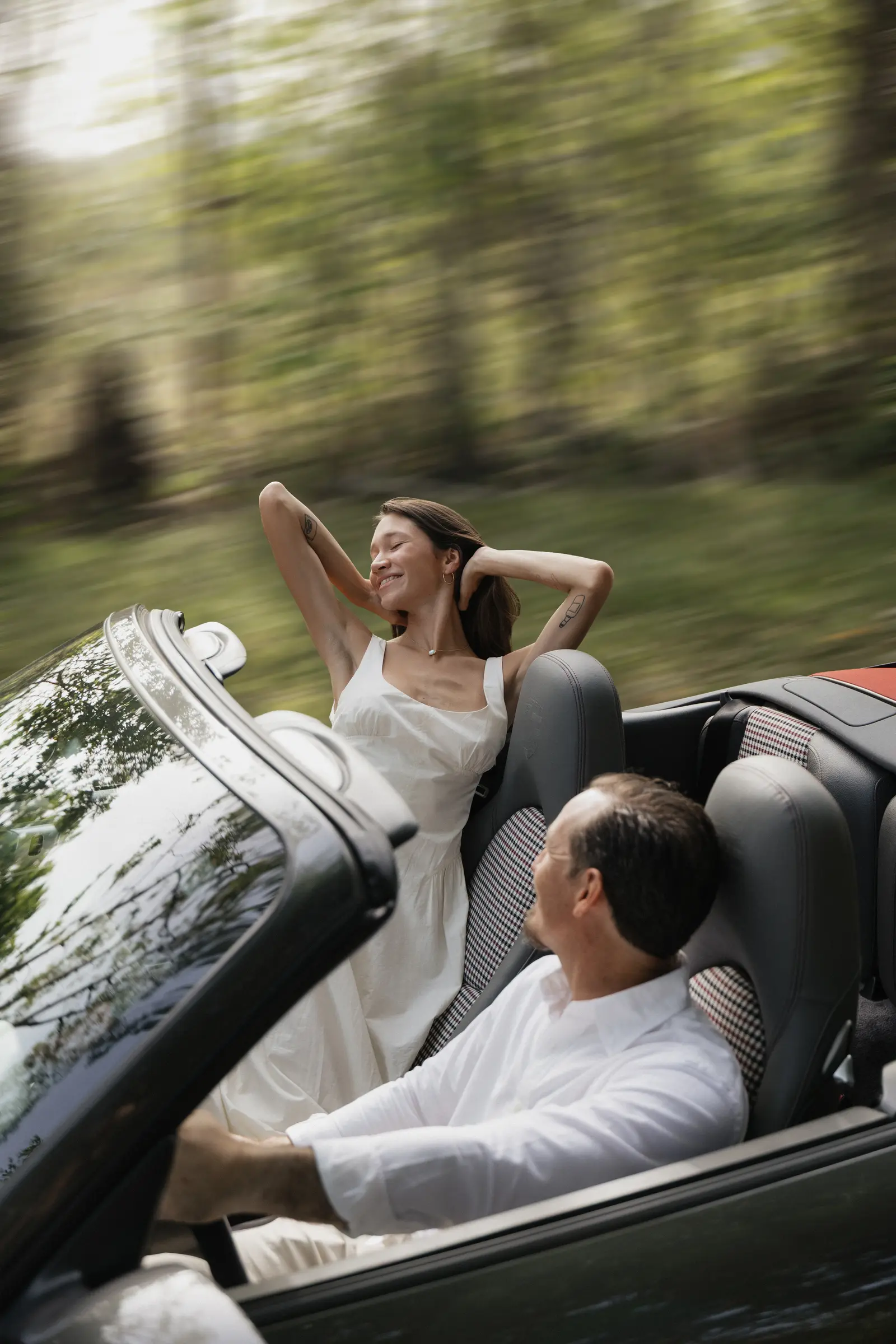 Bride relaxing in the back seat of a convertible car