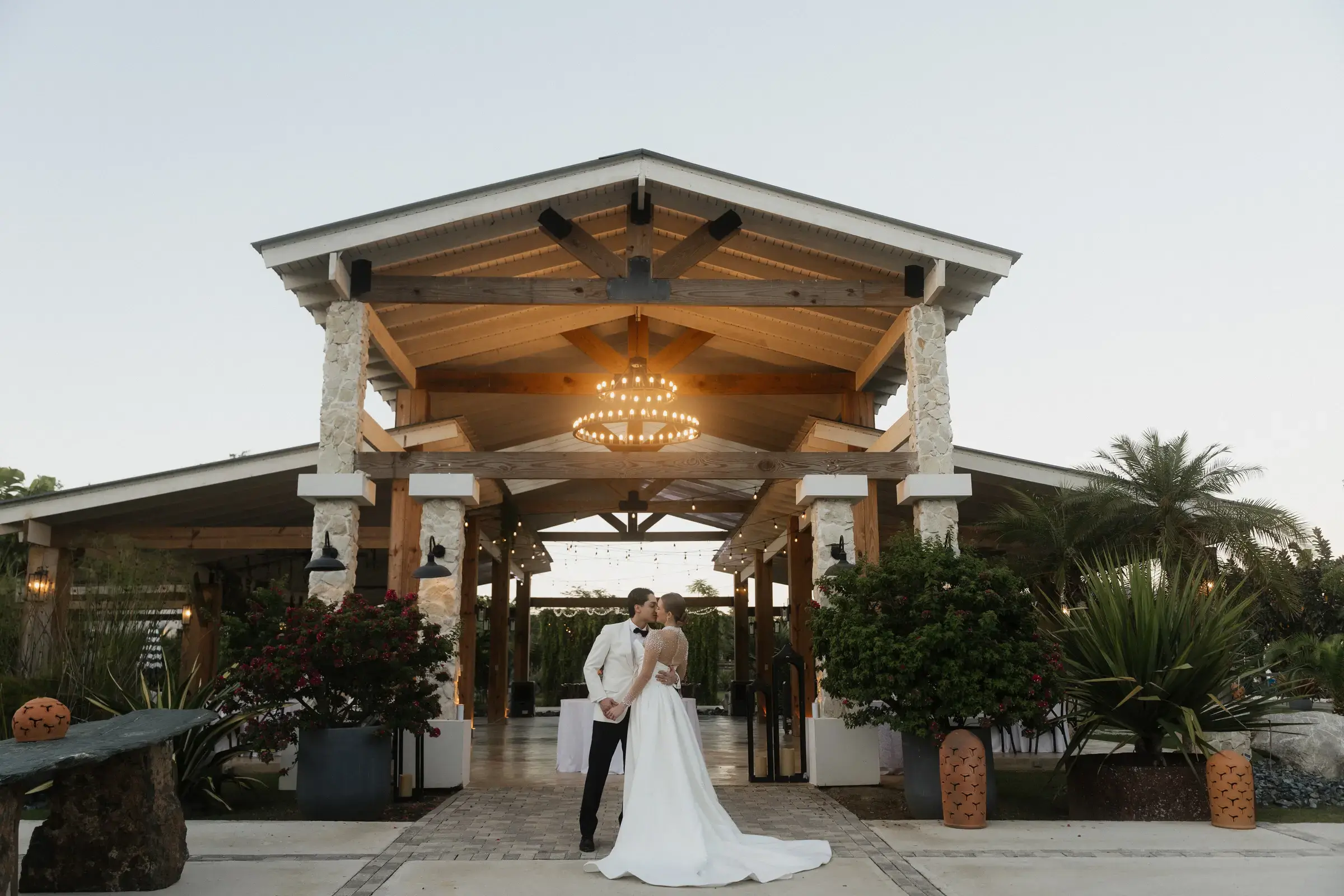 Wedding ceremony beneath an outdoor pavilion at dusk