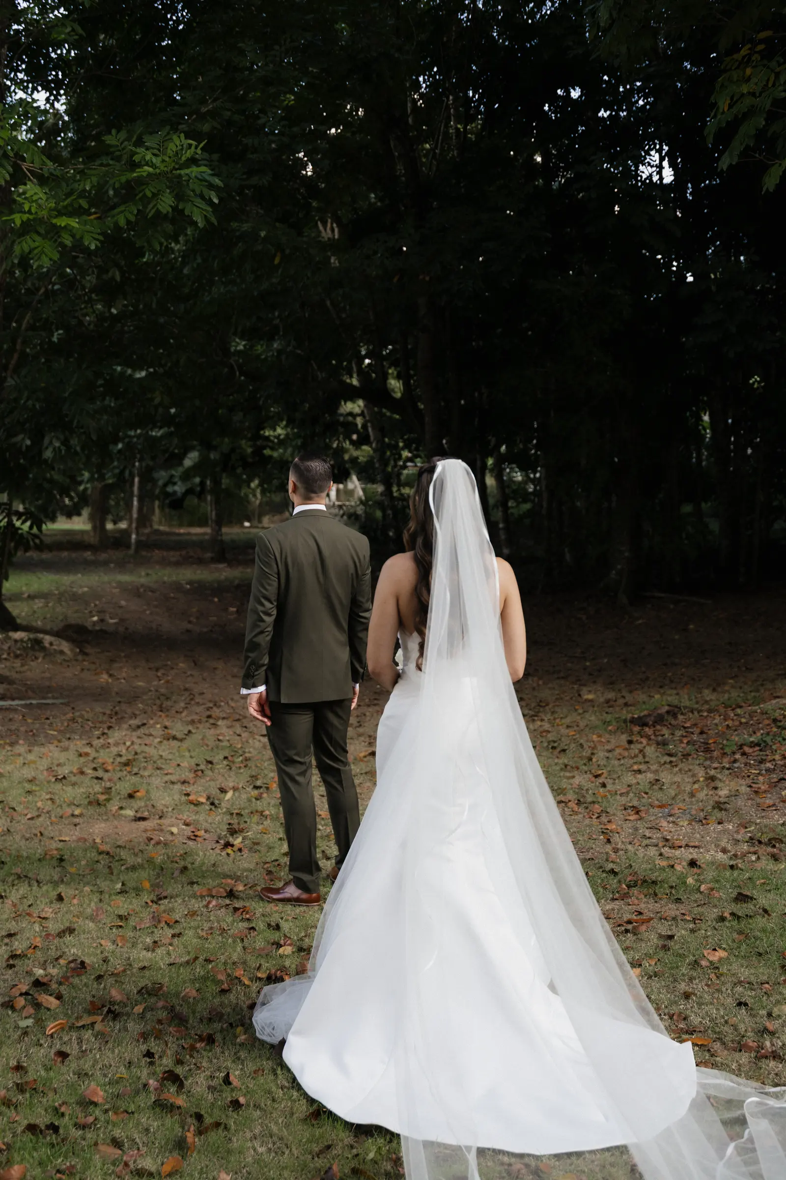 Bride and groom walking away hand in hand outdoors