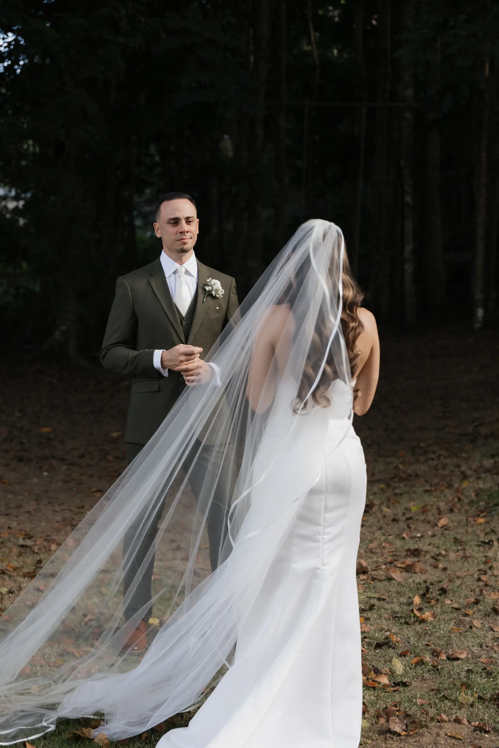 Bride with a long veil standing outdoors