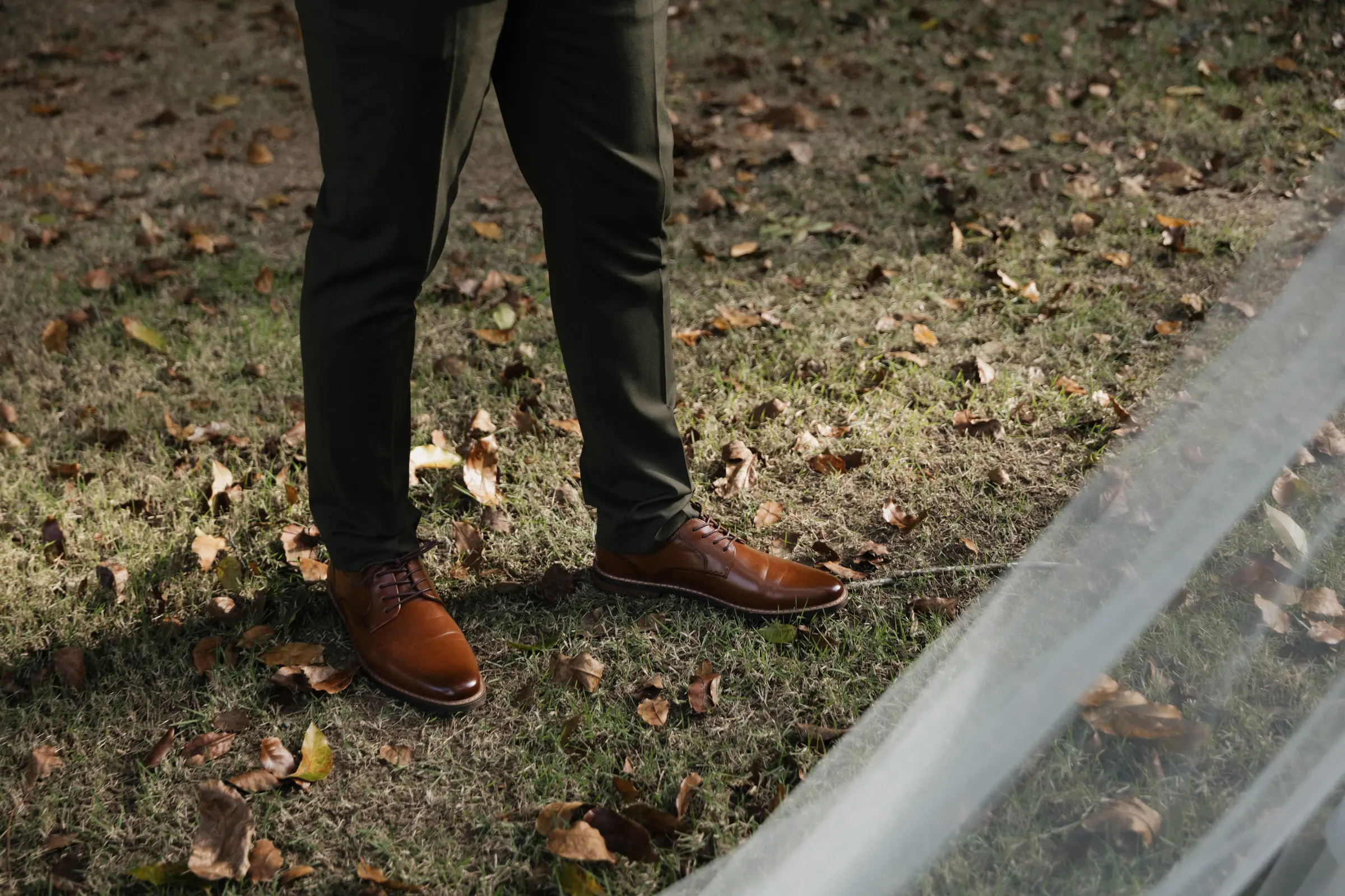 Close-up of the groom's shoes and pant cuffs outdoors