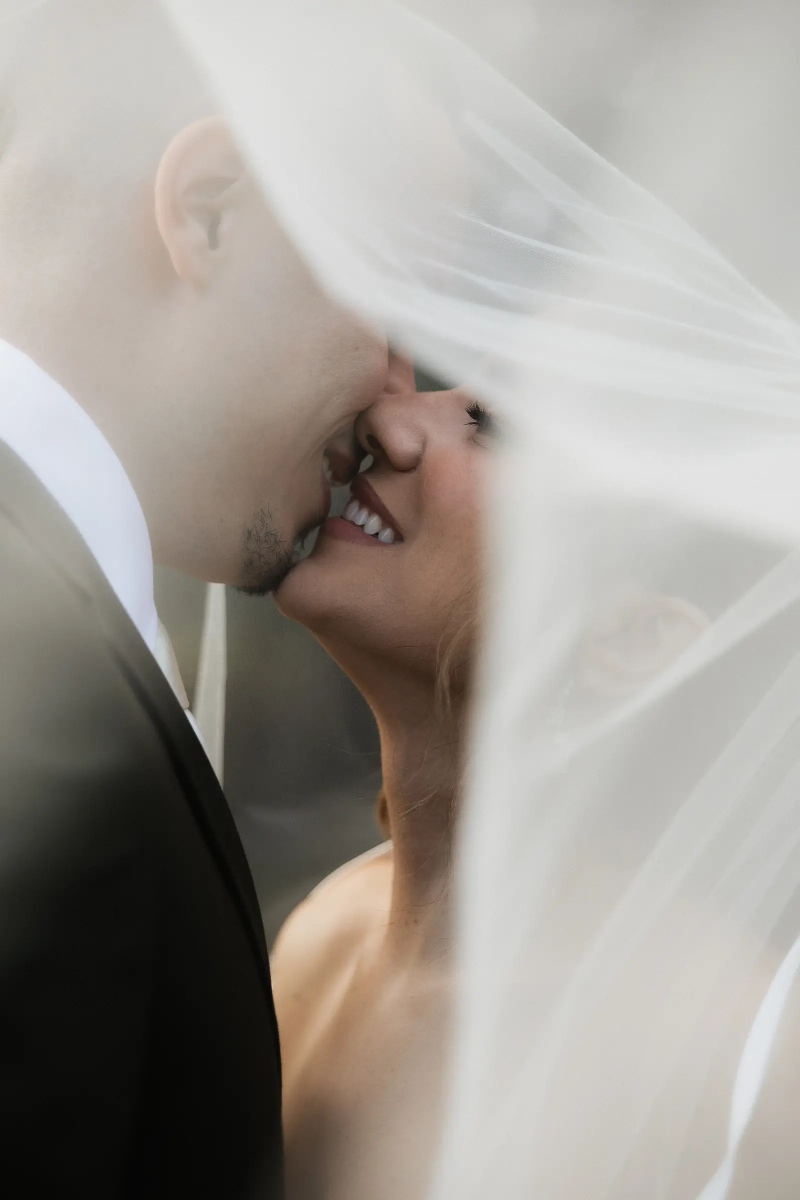 Bride and groom sharing a kiss under her veil
