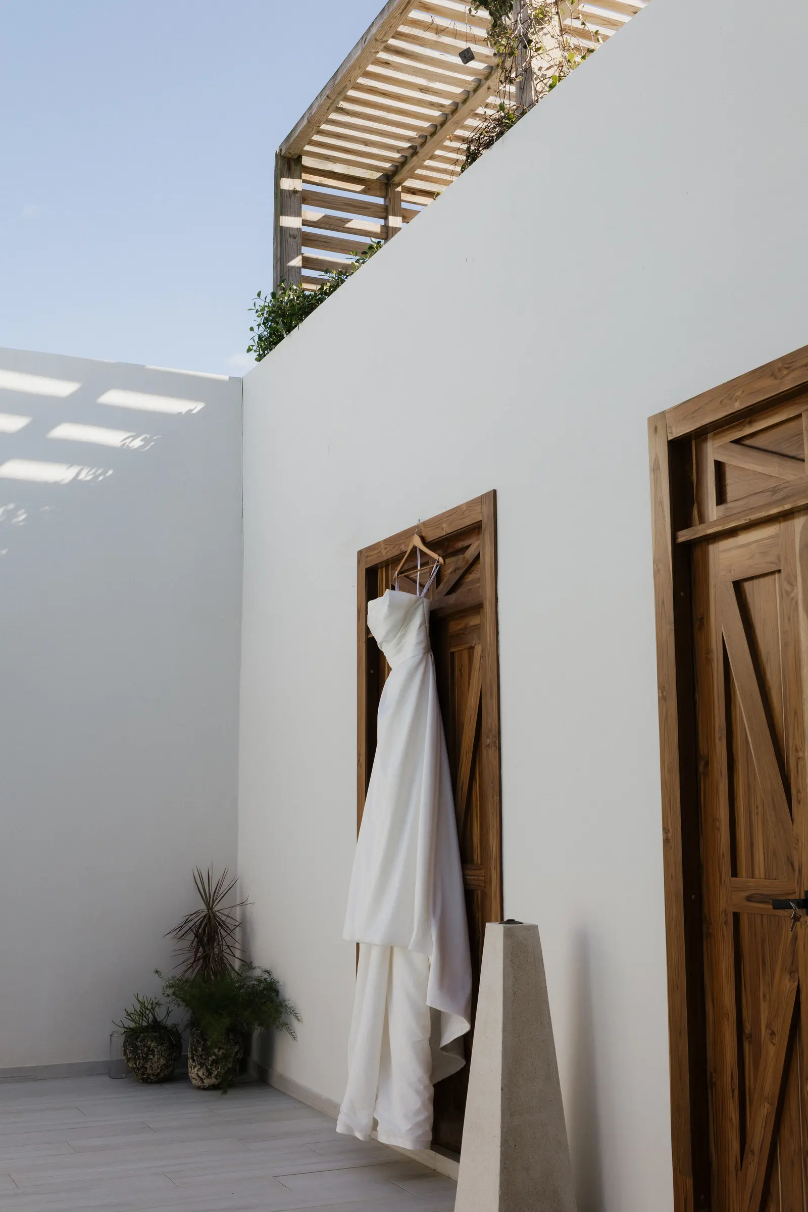 Wedding dress hanging outside a white stucco building