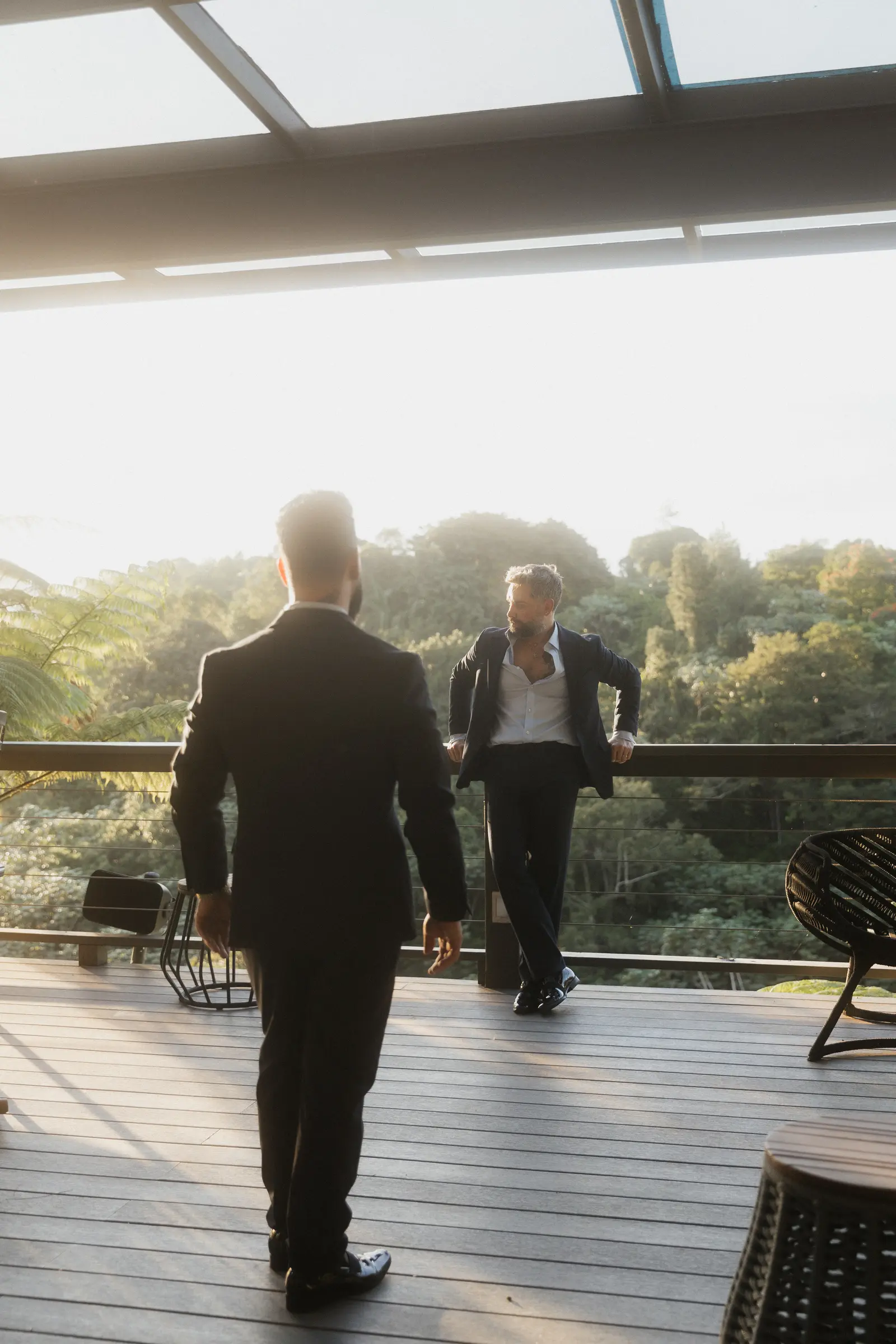 Groom walking with a guest along a deck