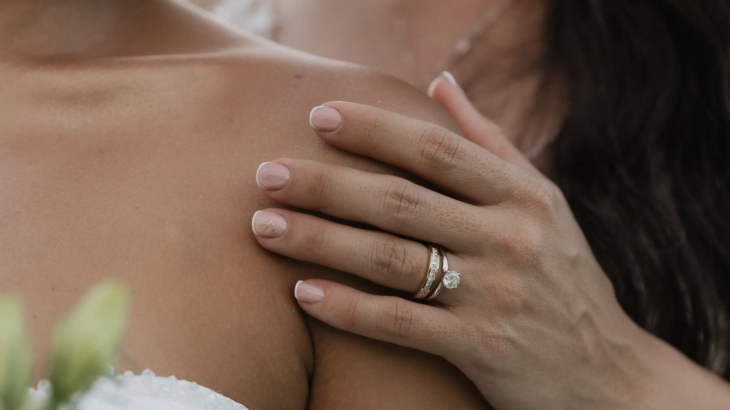 Close-up of a hand on a shoulder with a wedding ring