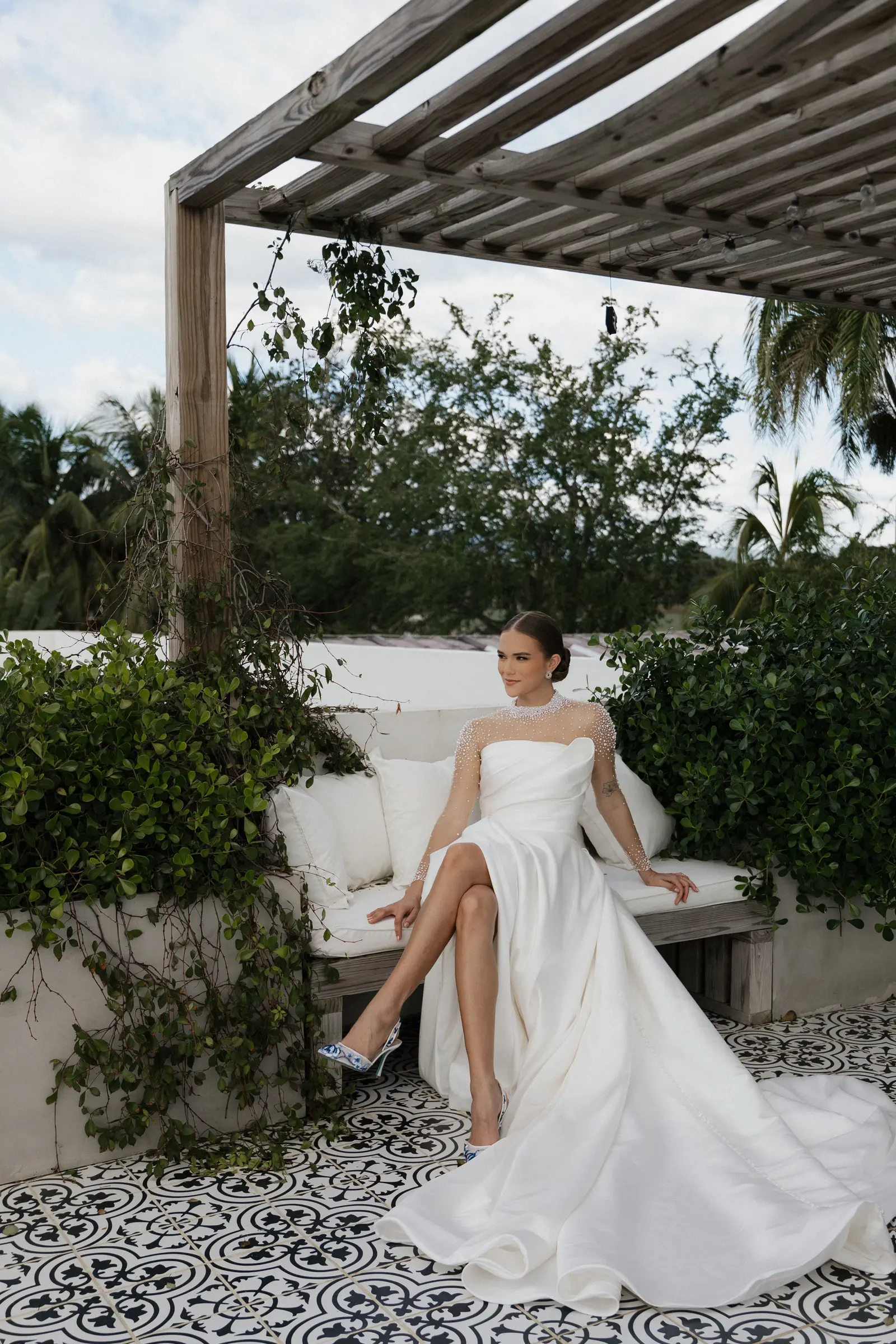 Bride sitting outdoors under a pergola