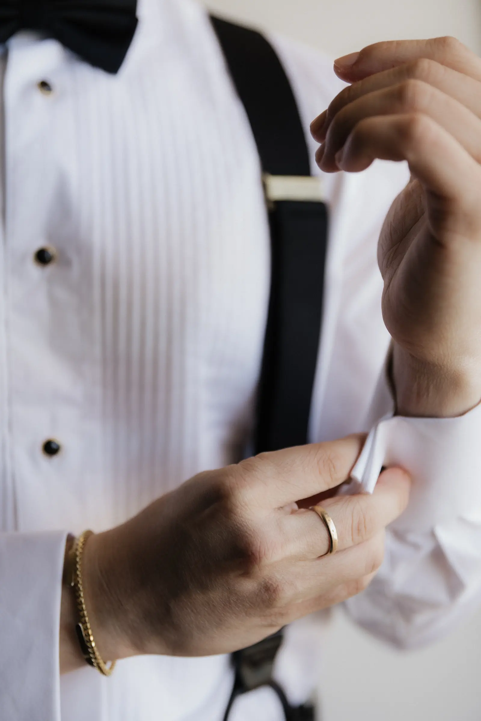 Close-up of the groom's cufflink and suspenders