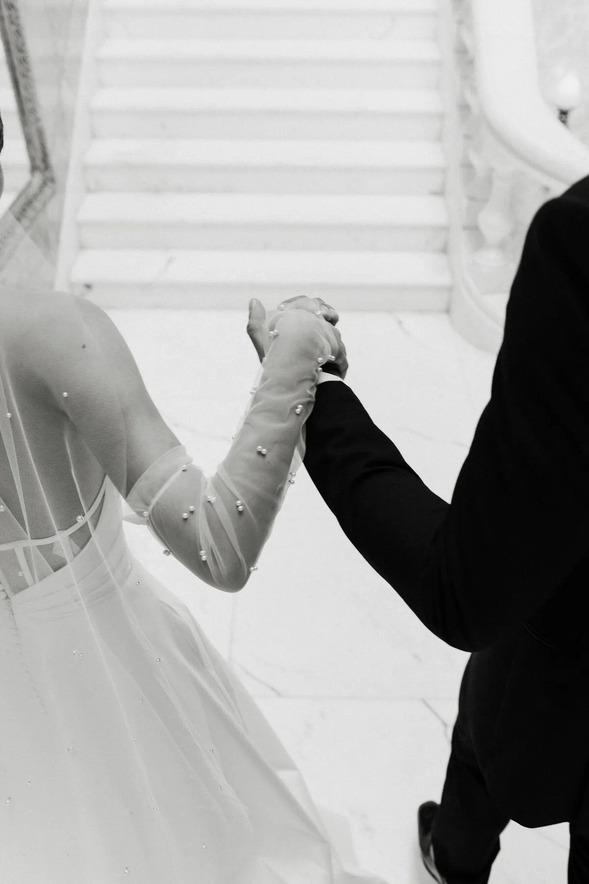 Black and white detail of hands and a bridal veil