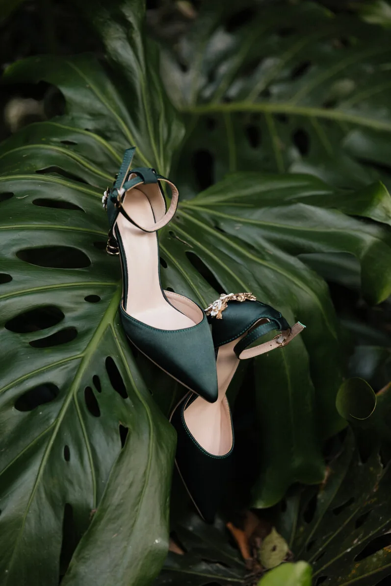 Bride's shoe resting on a monstera leaf during a tropical wedding session