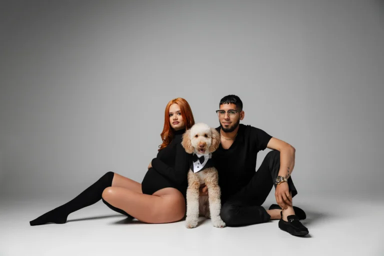 Couple with their dog seated together in a studio portrait