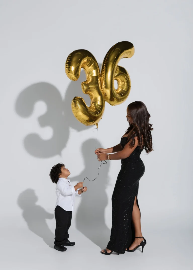 Woman celebrating her birthday with gold number balloons alongside her young son